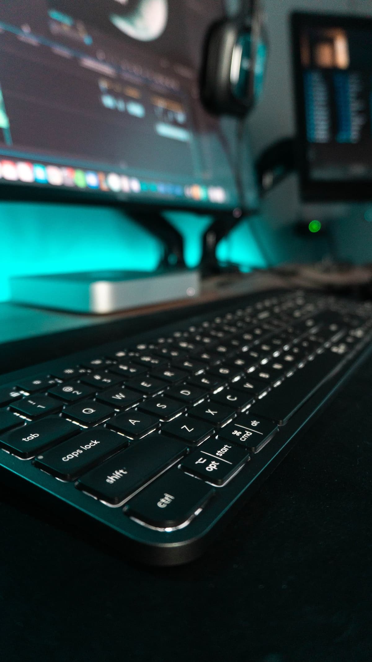Tastiera in primo piano con monitor per editing video sullo sfondo